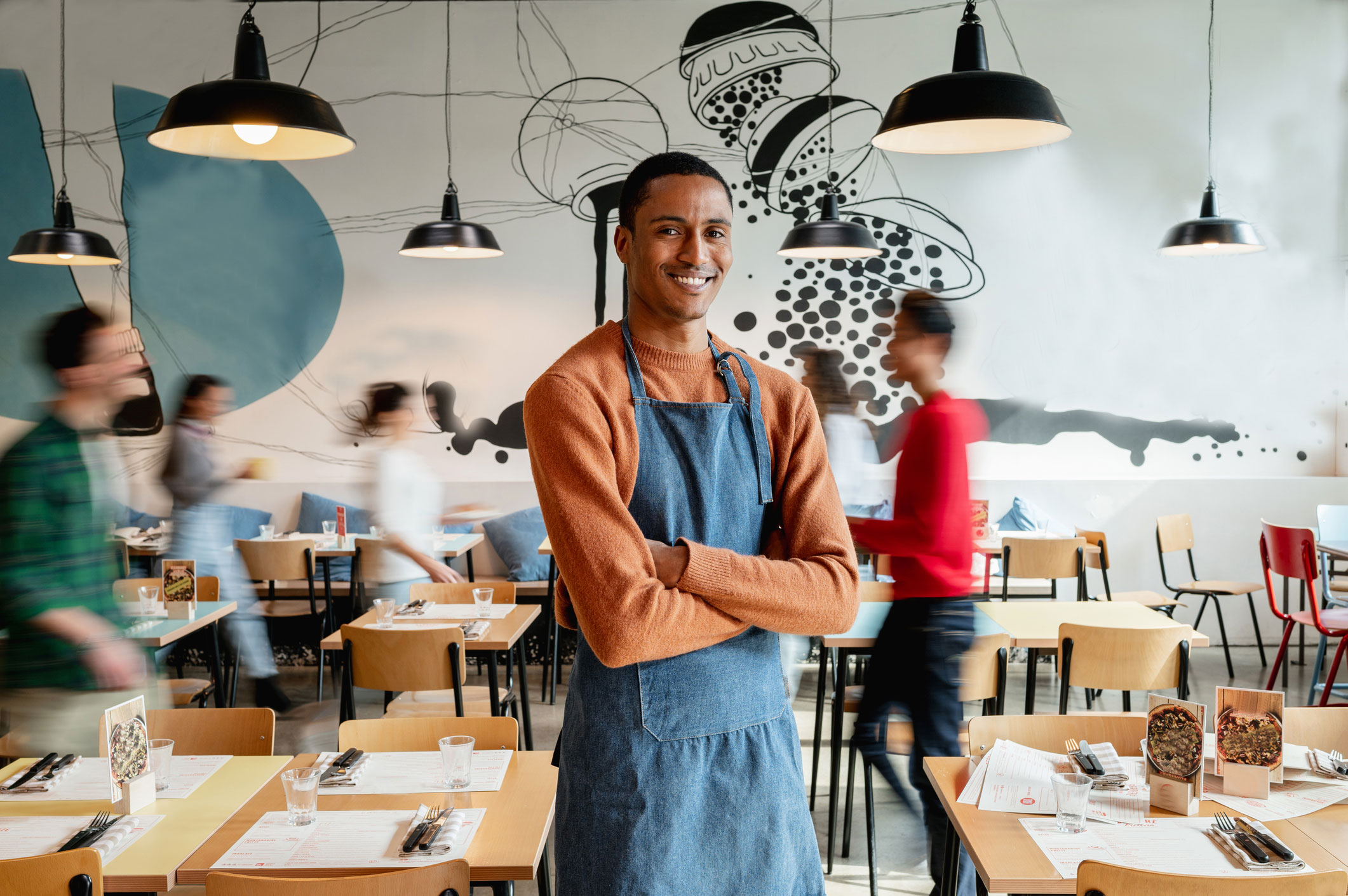 Owner of restaurant smiling at camera